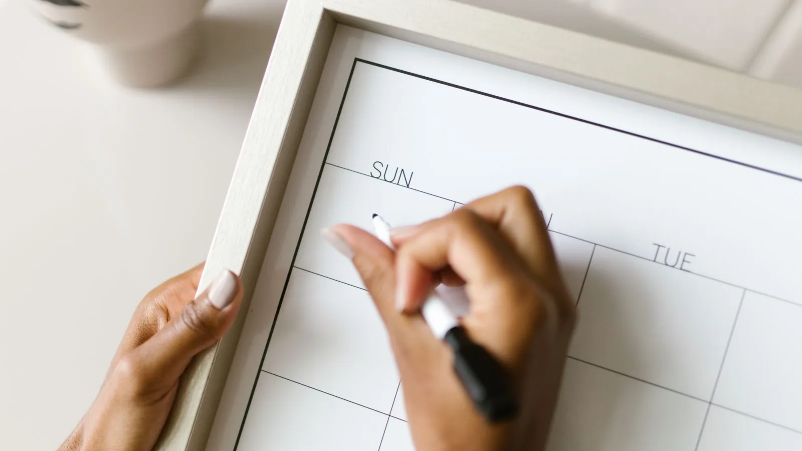 Frau trägt einen Termin in einen Kalender ein